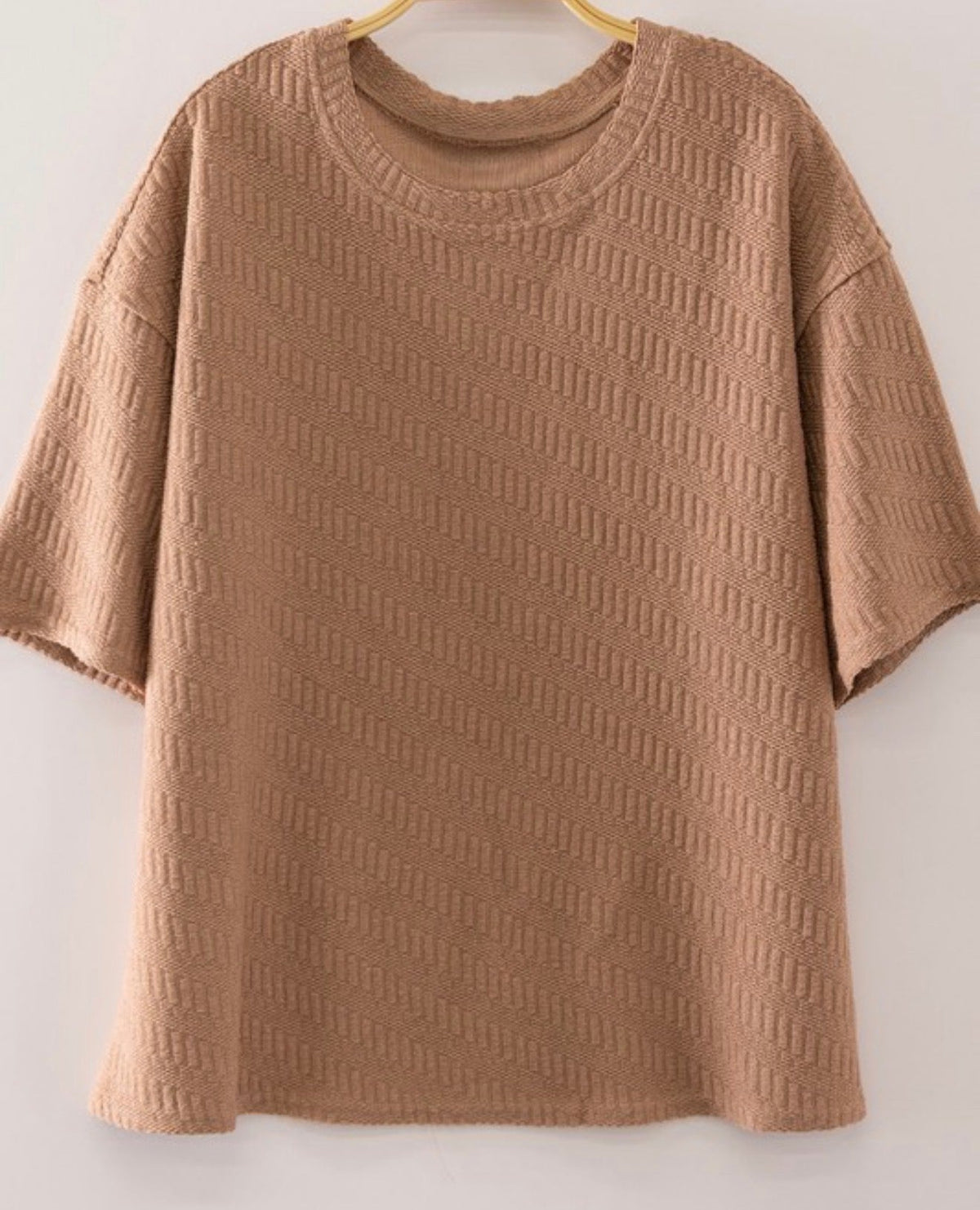 Muted taupe textured short sleeve top on a hanger